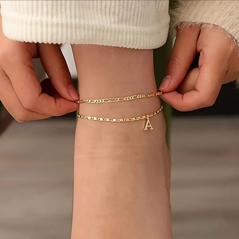 Sierlijke, gelaagde gouden enkelbandjes met initialen